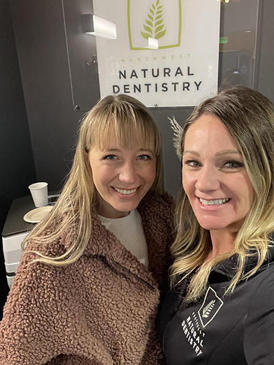dental staff members smiling for the camera in front of Northwest Natural Dentistry sign