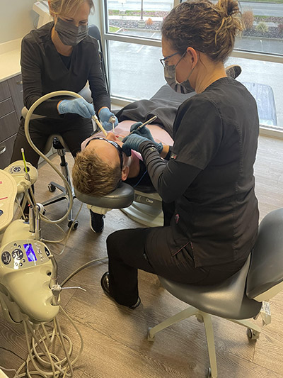 dental assistant working on an emergency dentistry patient
